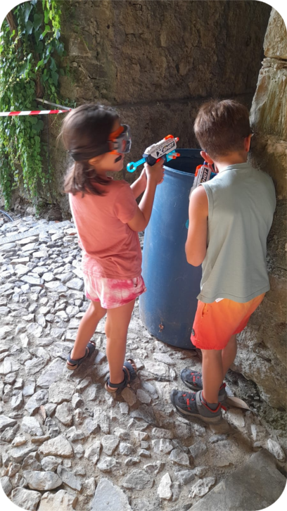 Pronti all’attacco! Due giovani guerrieri si nascondono tra i vicoli di Velva, concentrati a conquistare la bandiera avversaria nella Battaglia Nerf